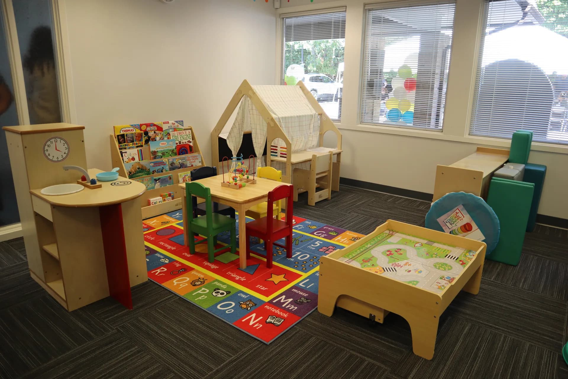 Collaborative ABA Services classroom with educational play areas, sensory tools, and learning rugs