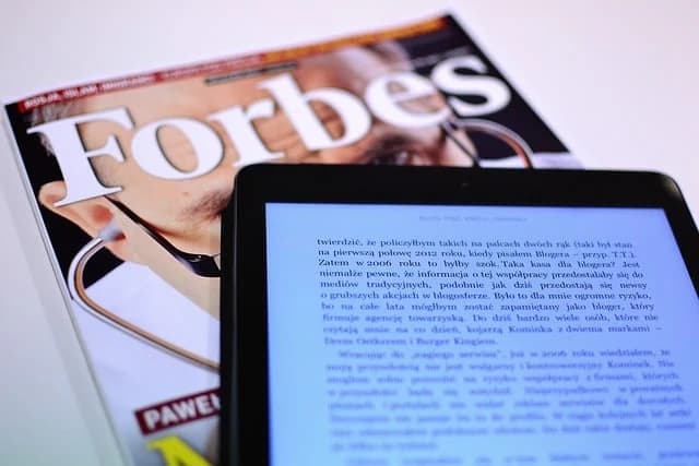 Forbes magazine alongside a tablet displaying an article — Collaborative ABA Services has been featured in major publications