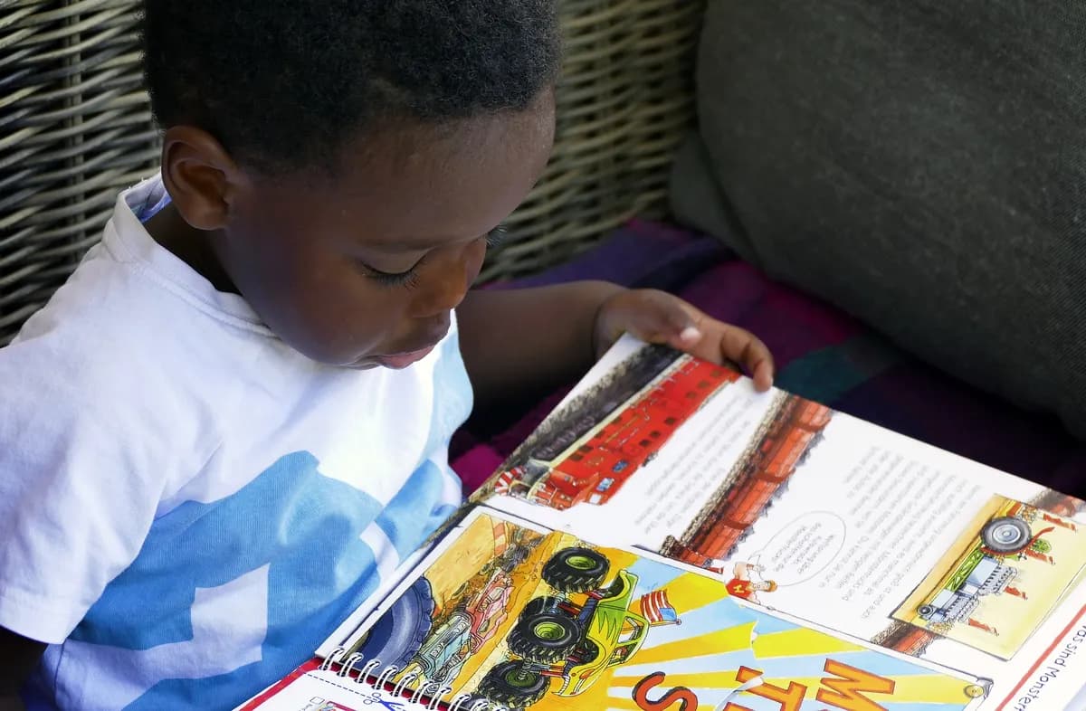 Young child reading a picture book, supporting speech and language development